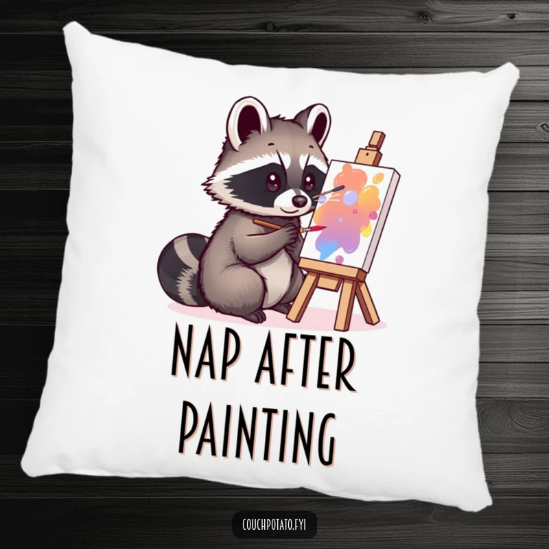 Funny curious raccoon painting on a small canvas, depicted on a plush pillow, offering humorous comfort and artistic flair.