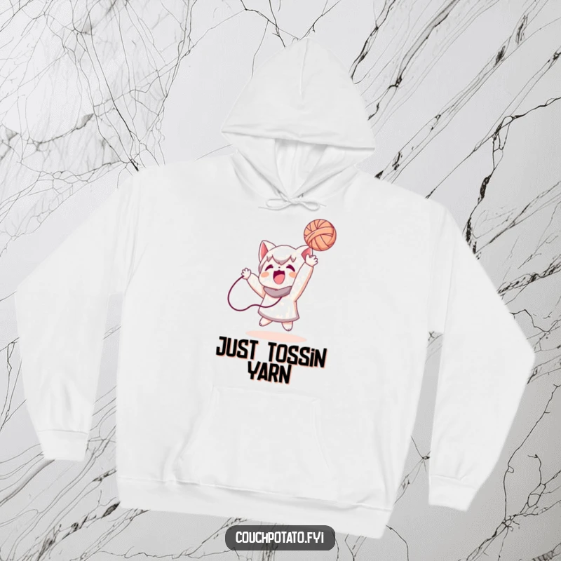 Funny hoodie featuring a character mid-air, playfully tossing a ball of yarn, designed for ultimate comfort and a humorous statement.