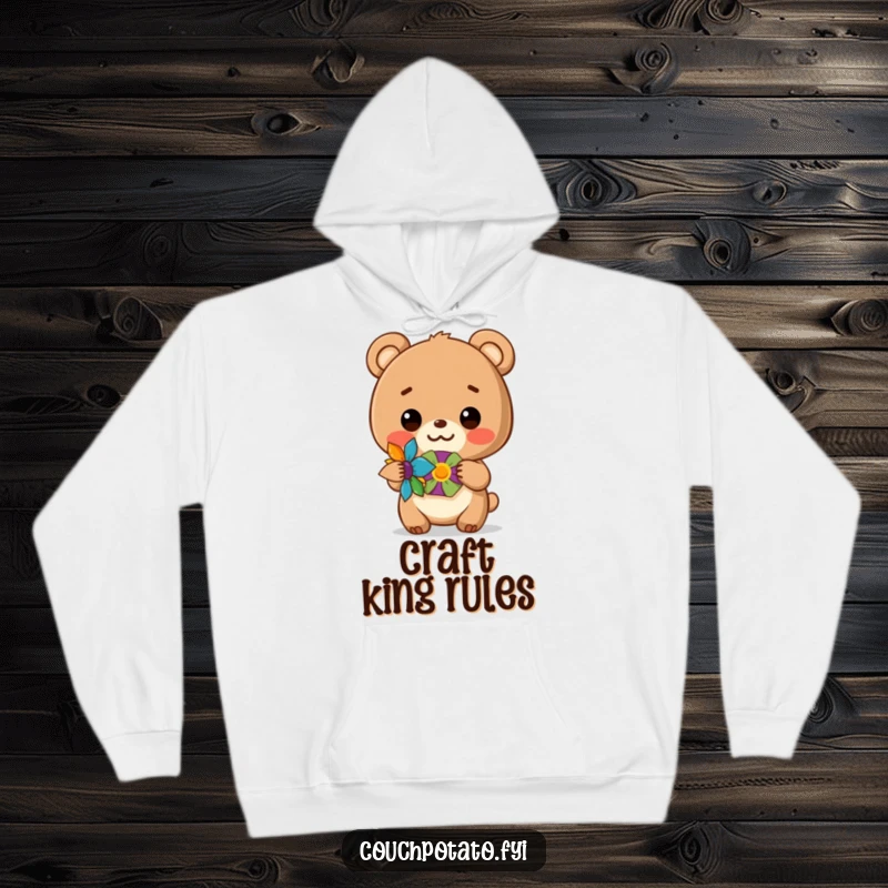 Funny hoodie featuring a happy bear cub showing off a colorful handmade craft, perfect for cozy crafting.